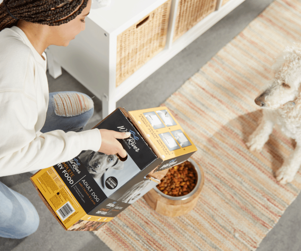 Girl using IntegraFlute to pour kibble in dog's bowl