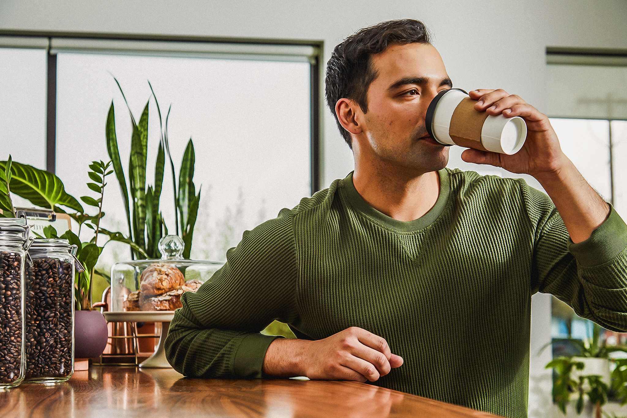 A man drinking a hot to-go cup of beverage