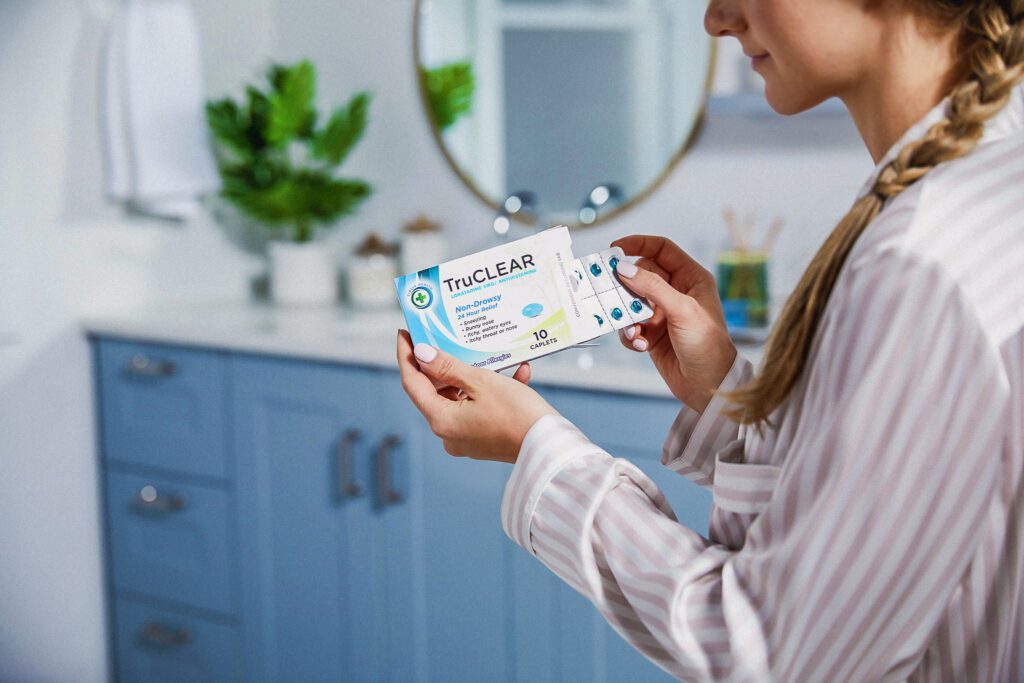 A woman opening her medication, showcasing a blister pack