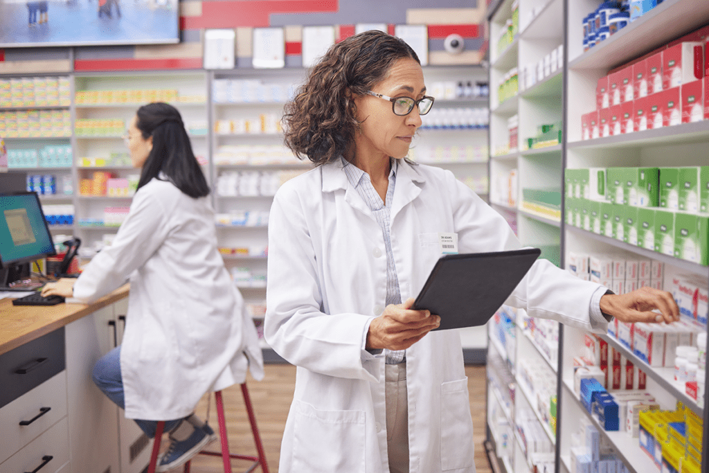 Pharmacist checking inventory with tablet