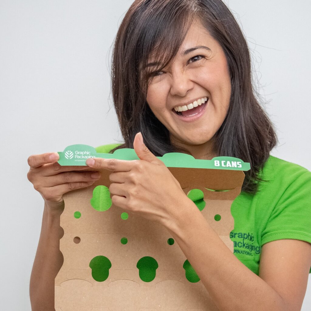 An employees proudly showing Graphic Packaging's logo on a packaging