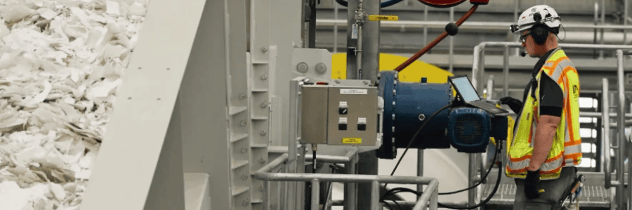 Input line operator overseeing paperboard material processing equipment used in sustainable packaging manufacturing at Graphic Packaging's Waco facility.